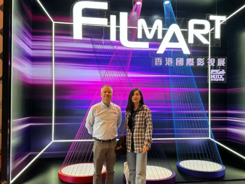 "Bryan Head, VP of Sales PH, and Fayme Magallanes, Managing Director at Arcadian, stand in front of the vibrant FILMART 2025 display at the Hong Kong Convention and Exhibition Centre. 