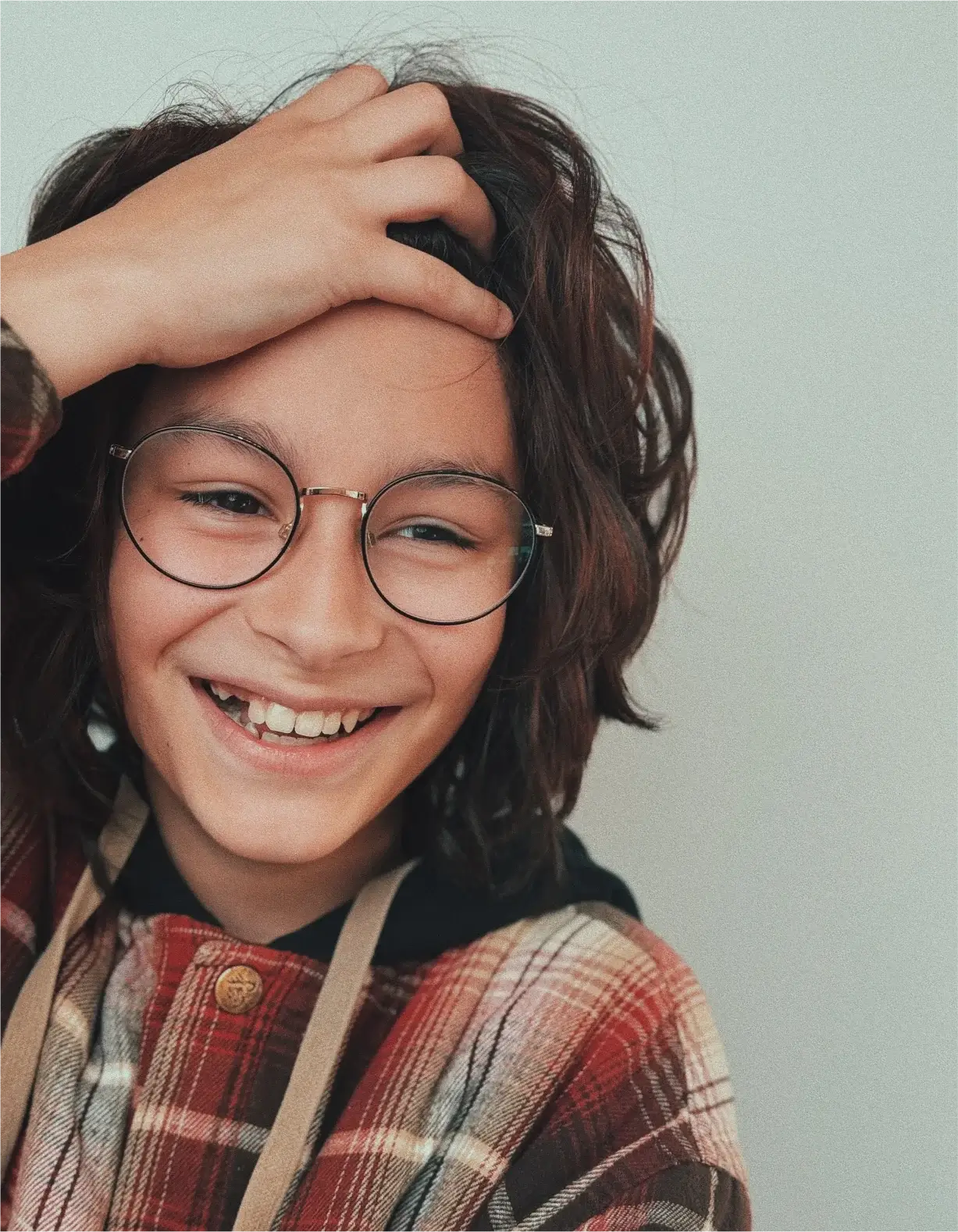 A young man with glasses and a red plaid shirt.