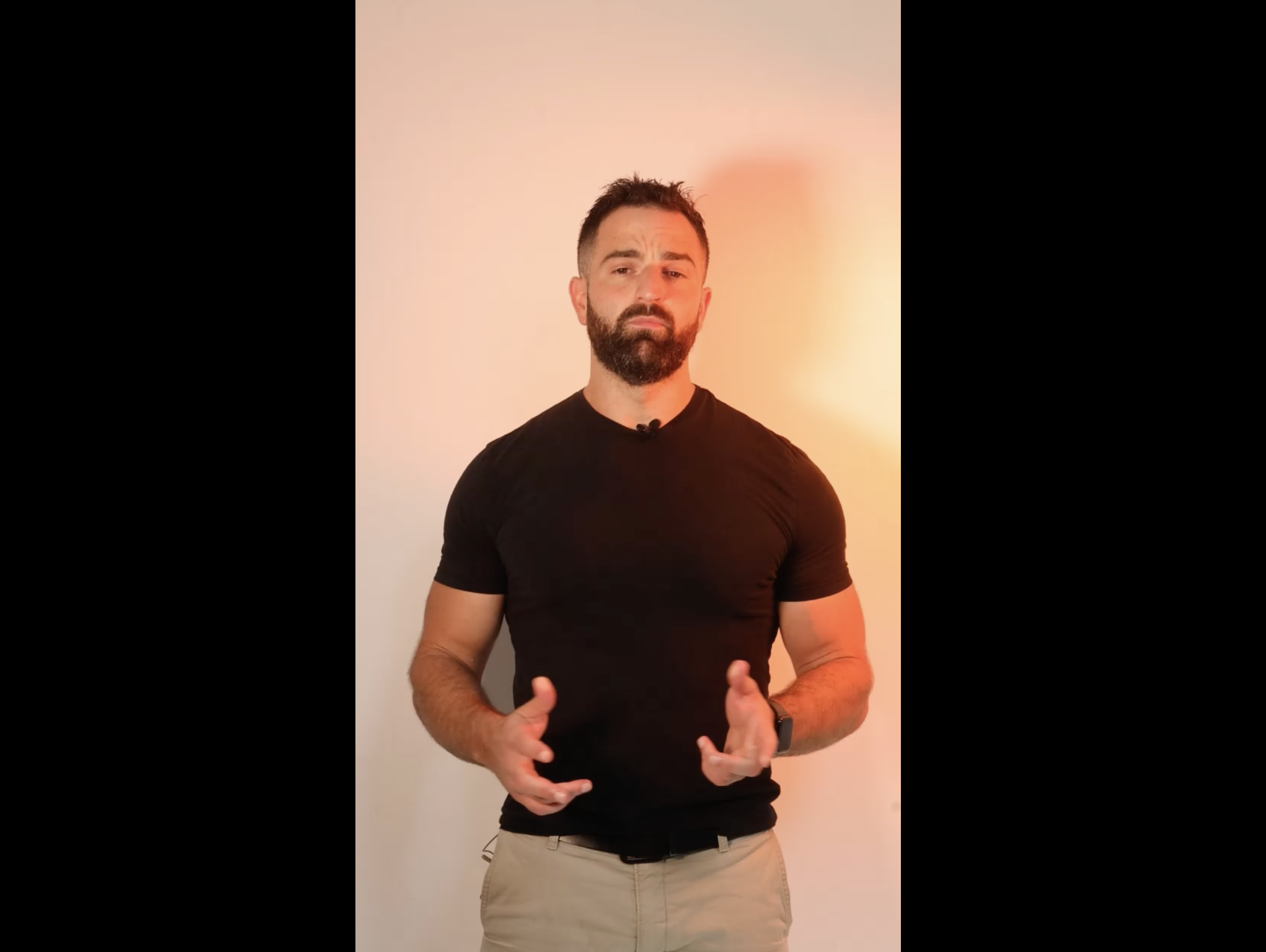 Un homme en T shirt noir, parlant en utilisant les mains