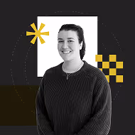 A smiling woman wearing a dark sweater stands against a black background with geometric shapes in white and yellow. She has her hair pulled back and is facing the camera.