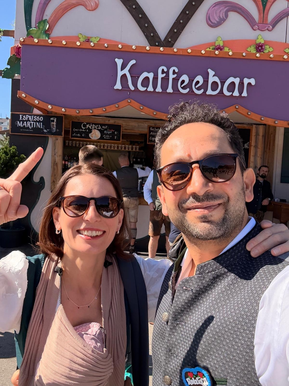 Two guests in Tracht in front of the Kaffeebar at the Oktoberfest