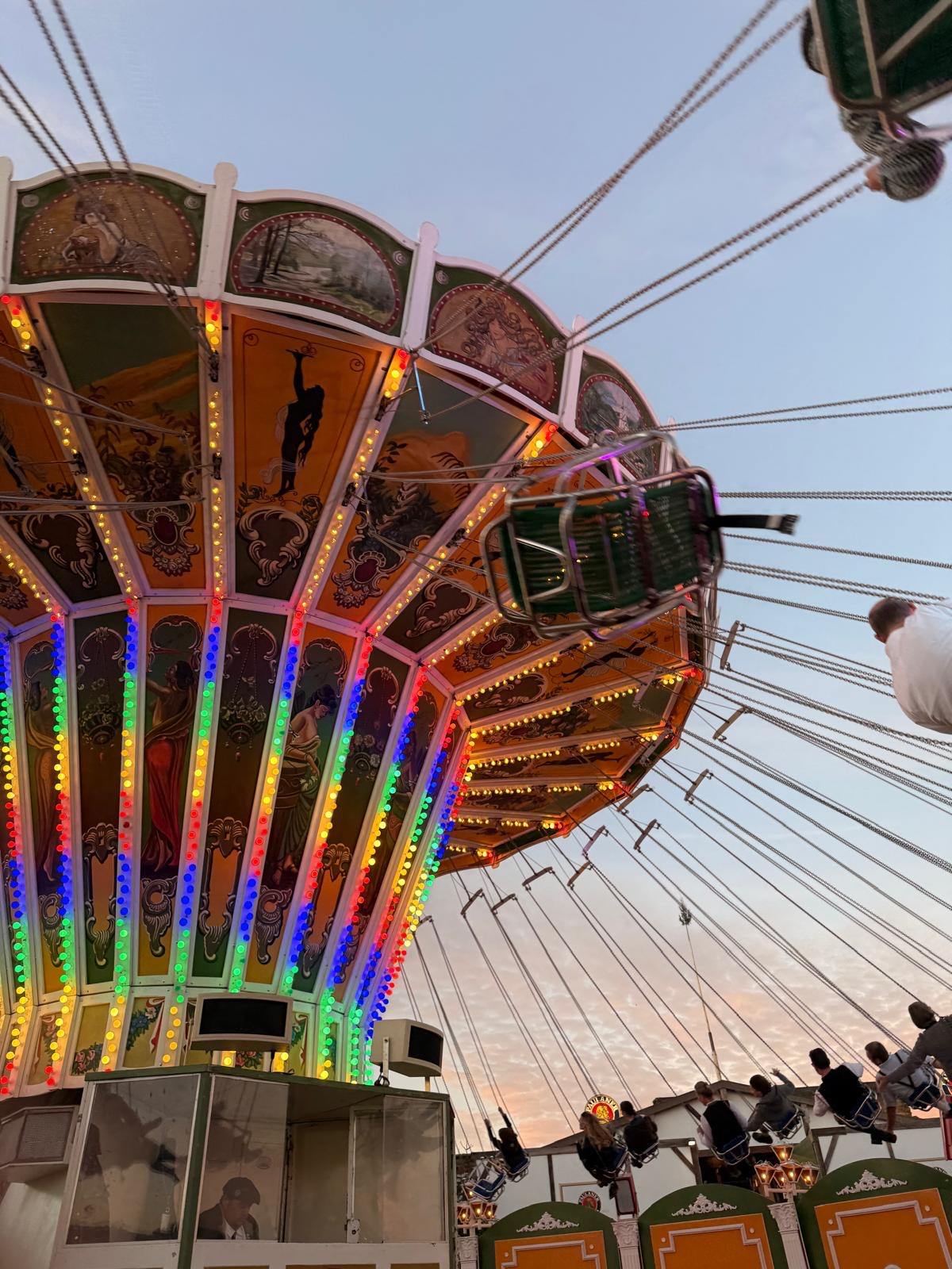 The chain carousel at the Oktoberfest at dusk, lights on, riders in the air