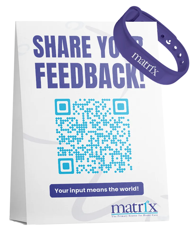 Table display with a QR code sign reading “Share Your Feedback!” and a purple Matrix wristband, illustrating Smart QR feedback collection