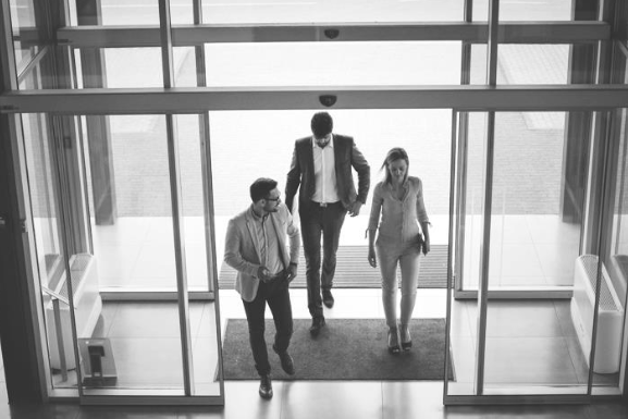 Group of people walking into a modern building