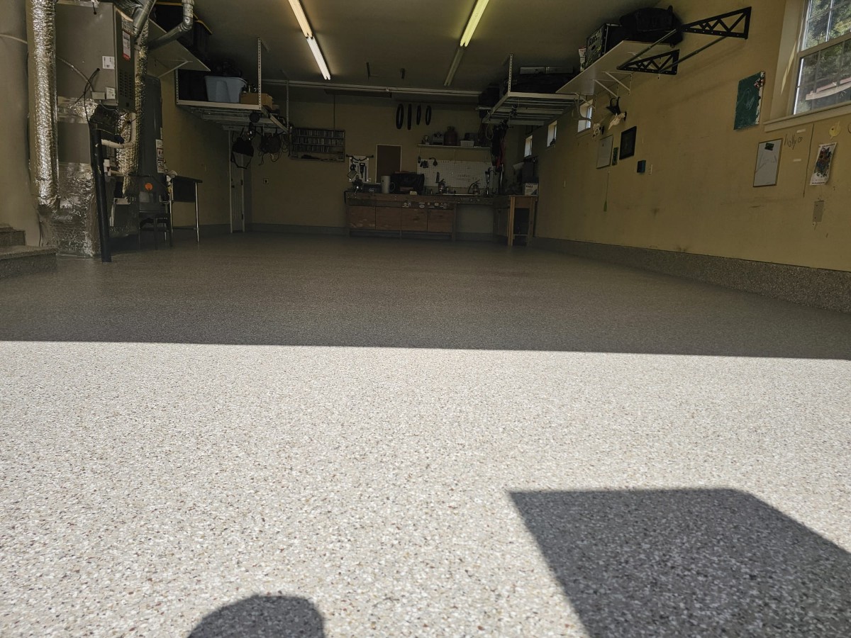 Light flake epoxy garage floor with a coved base along the wall