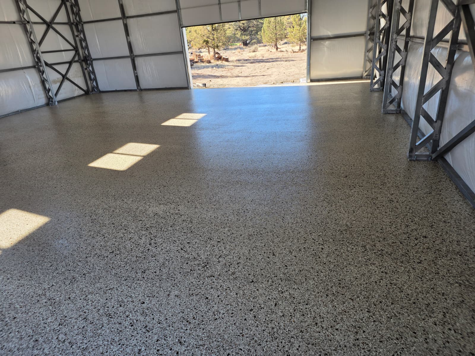 Tan, brown and black flake epoxy floor in a steel-frame shop building