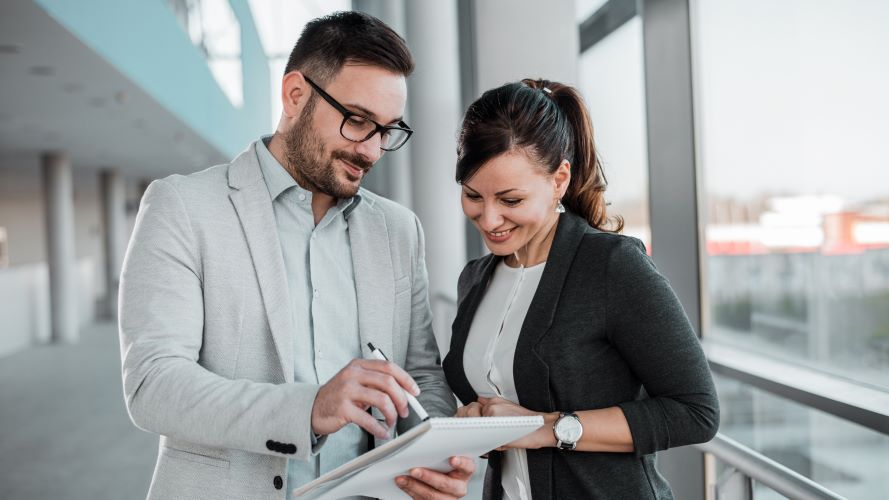 Photo of two people looking at a notepad