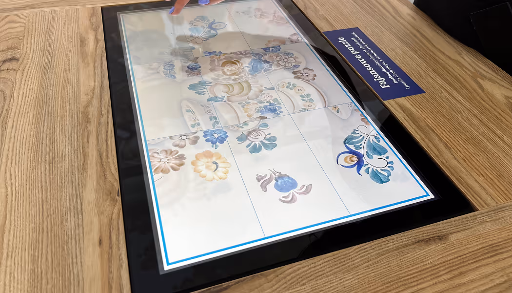 Inny widok ekranu z aplikacją muzealną dla dzieci do układania puzzli fajansowych w Skarbcu Fajansu. Detal interaktywnego UI.