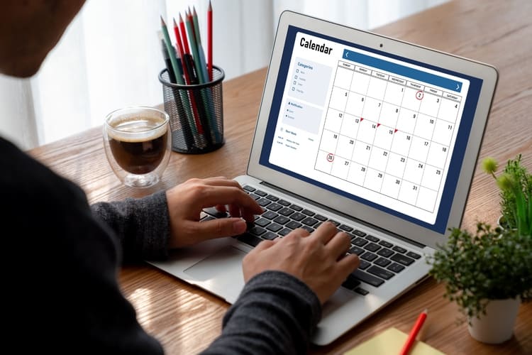 Person reviewing a digital calendar on a laptop representing content planning, organization and marketing strategy Avant