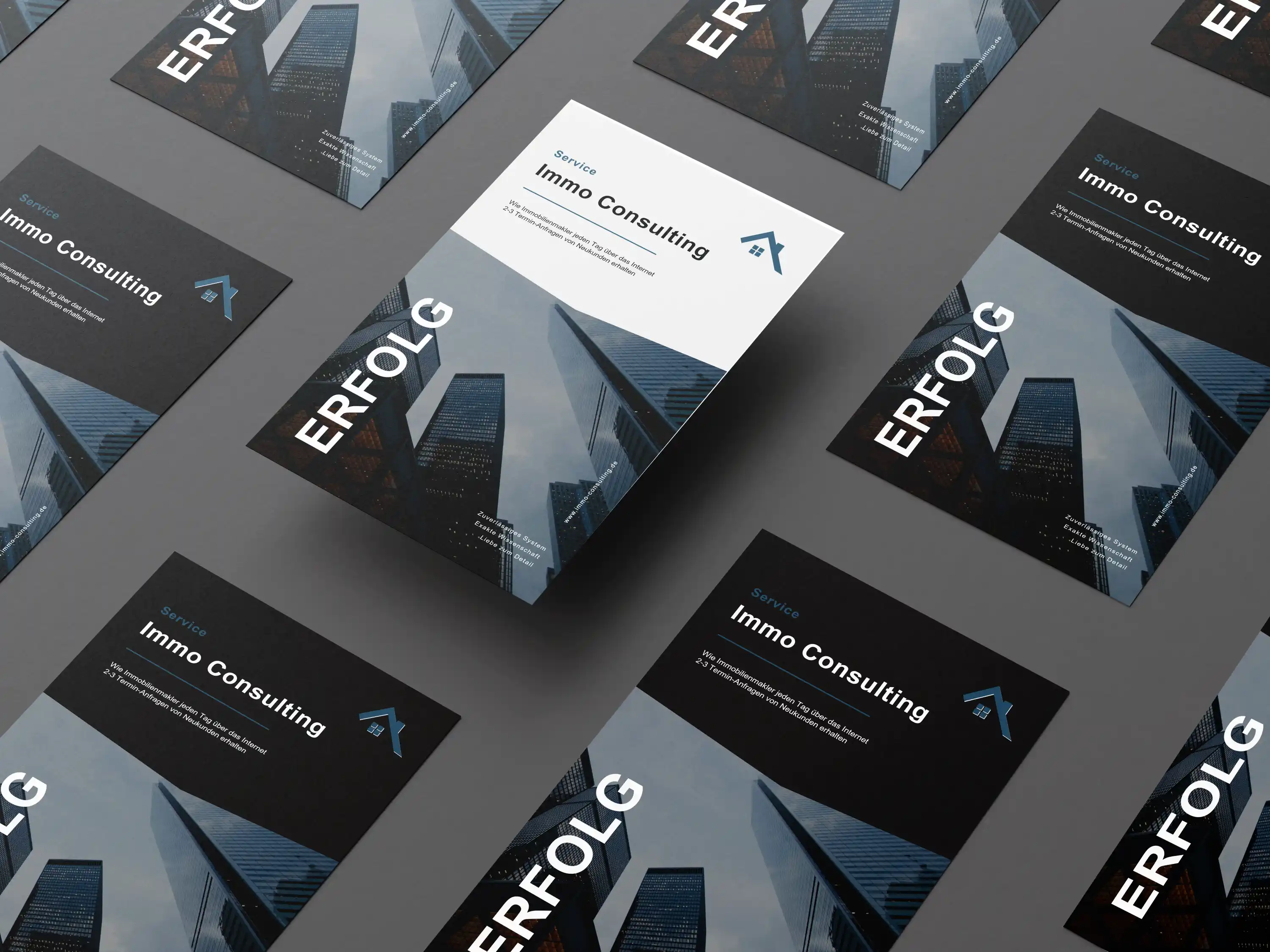 Mehrere Visitenkarten im Print Medien Design mit dem Text "Immo Consulting" und dem Wort "ERFOLG". Die Karten zeigen eine moderne, grafische Gestaltung mit Gebäuden im Hintergrund.