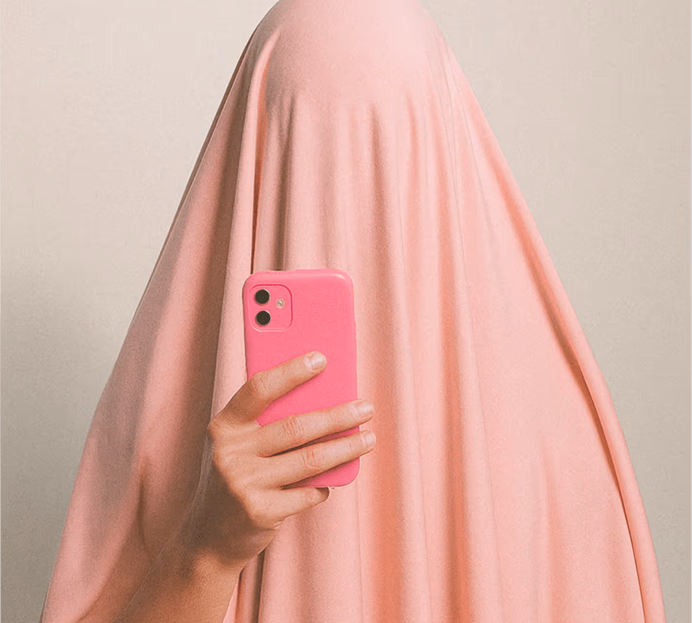 Person covered in a pink sheet holding a pink phone in front of their face.