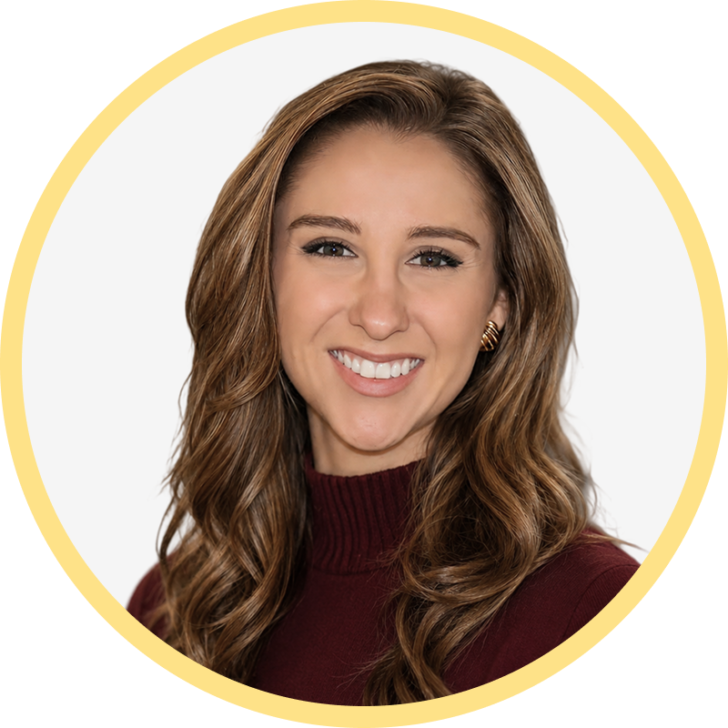 Smiling woman with long wavy brown hair wearing a maroon turtleneck and gold earrings.