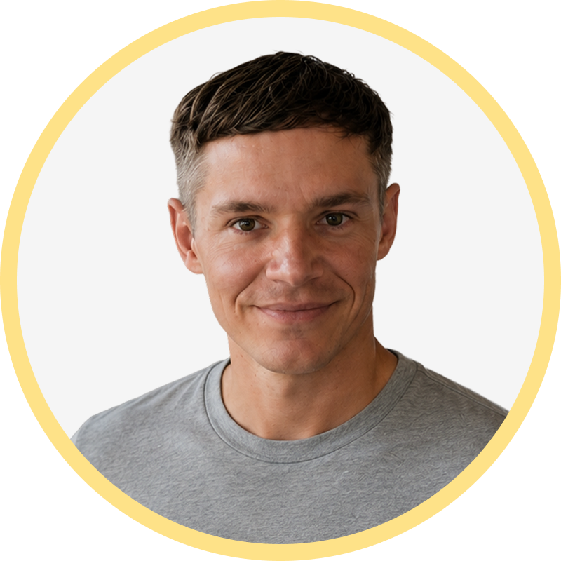 Smiling man with short brown hair wearing a gray t-shirt inside a yellow circle frame.
