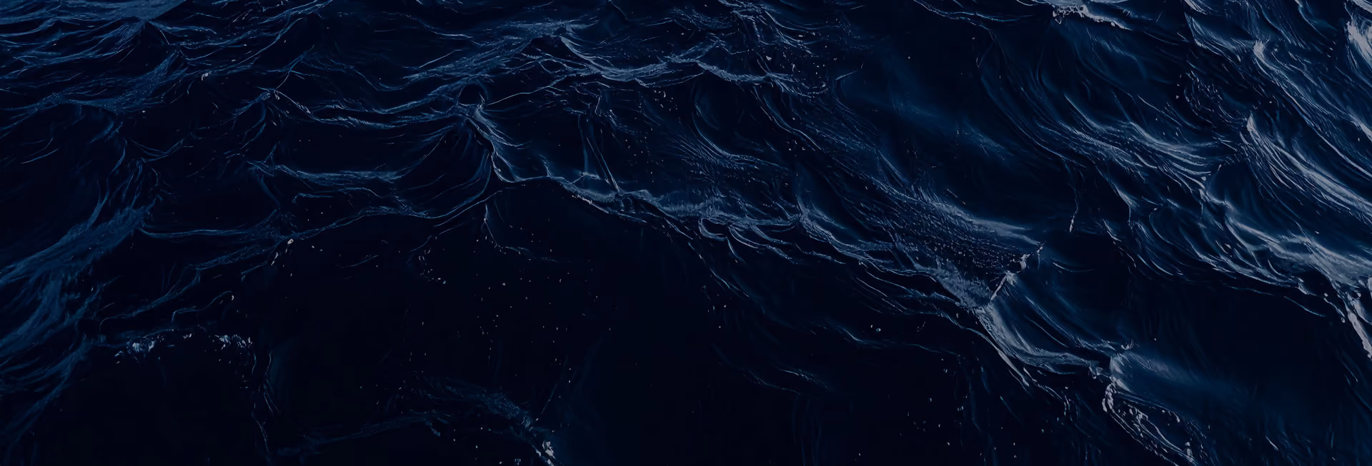 Close-up view of dark ocean waves with textured ripples and light reflections.