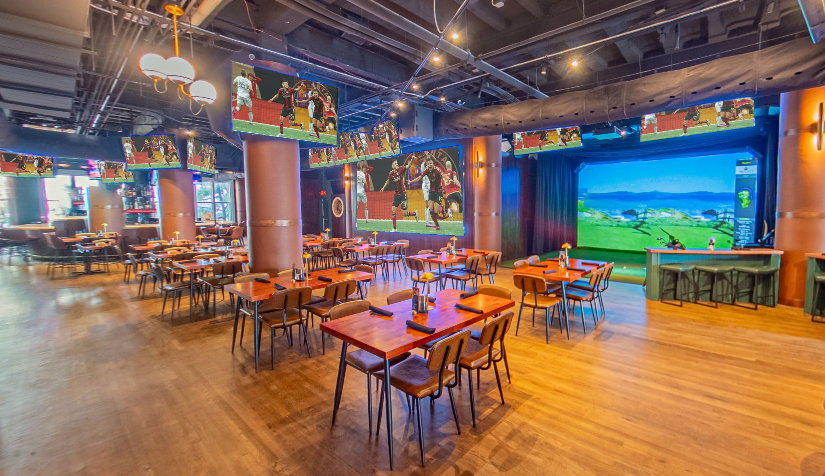 Sports bar dining room with a golf simulator bay and wall length printed graphics