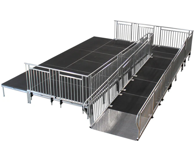 Modular ADA stage ramp with railings at a 1:12 slope connecting ground level to a stage deck