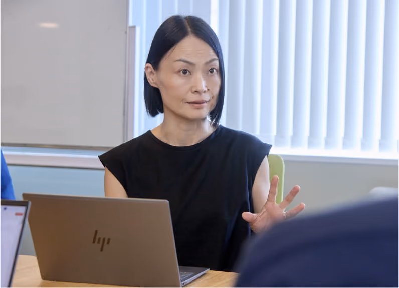 会議で発言する女性社員