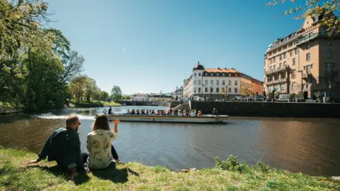 Happy Visuals Goteborg Two people watching a boat go past in the centre of Gothenburg