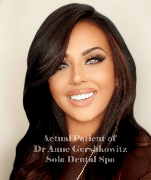 Close-up portrait of a smiling woman with long dark hair and bright eyes.