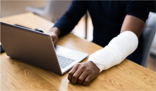 Man working on his laptop after a hand fracture treatment