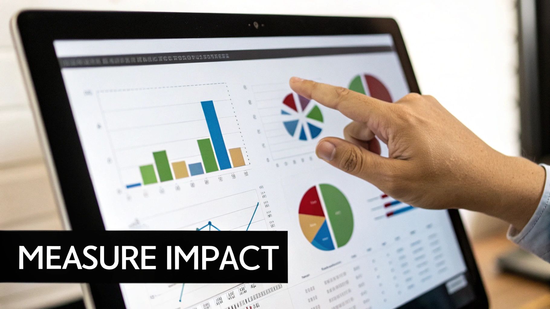 A hand points at a tablet screen displaying colorful business graphs and charts, emphasizing data analysis.