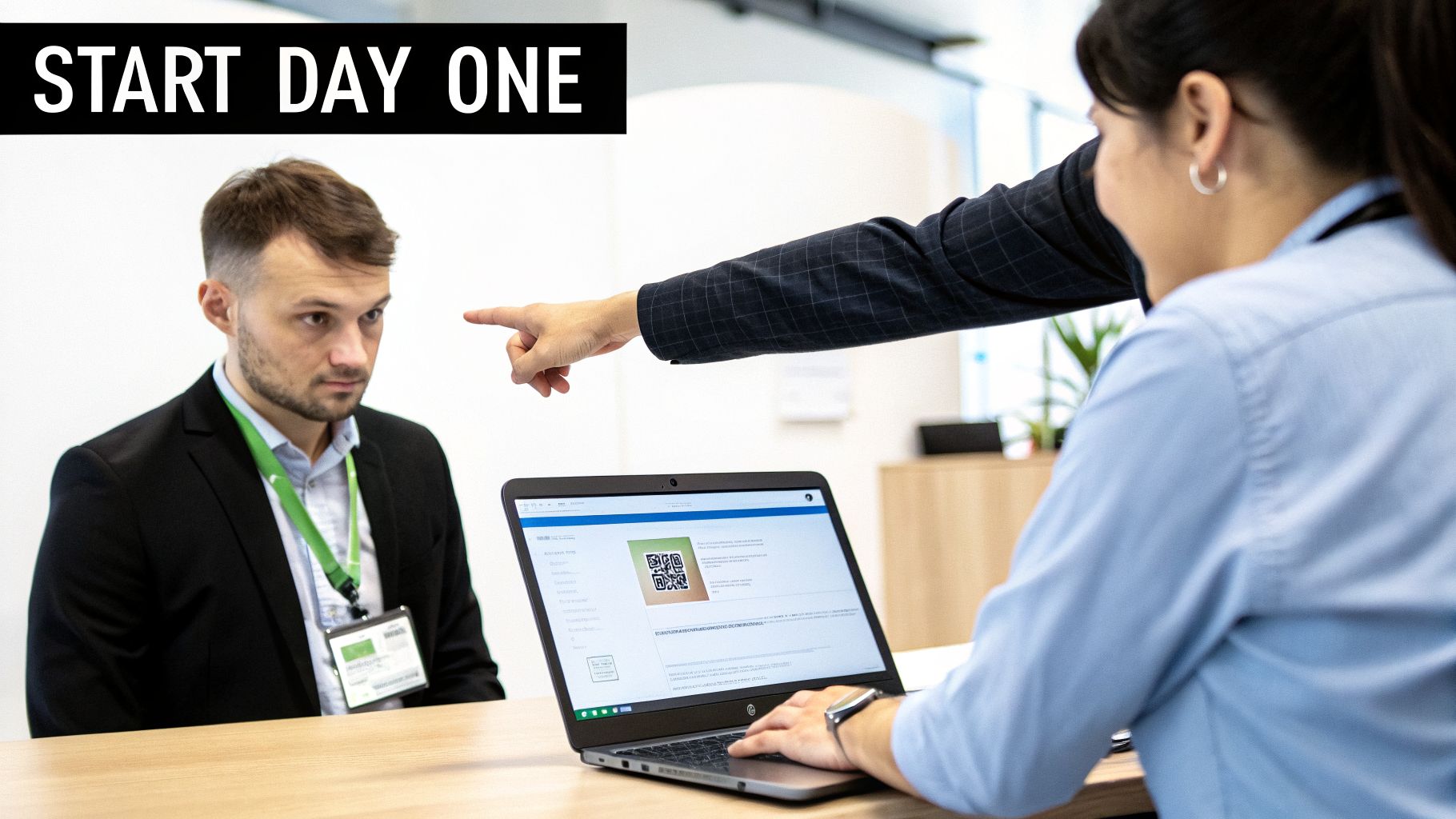 Start day one: A new hire looks at a laptop while a colleague points at the screen.