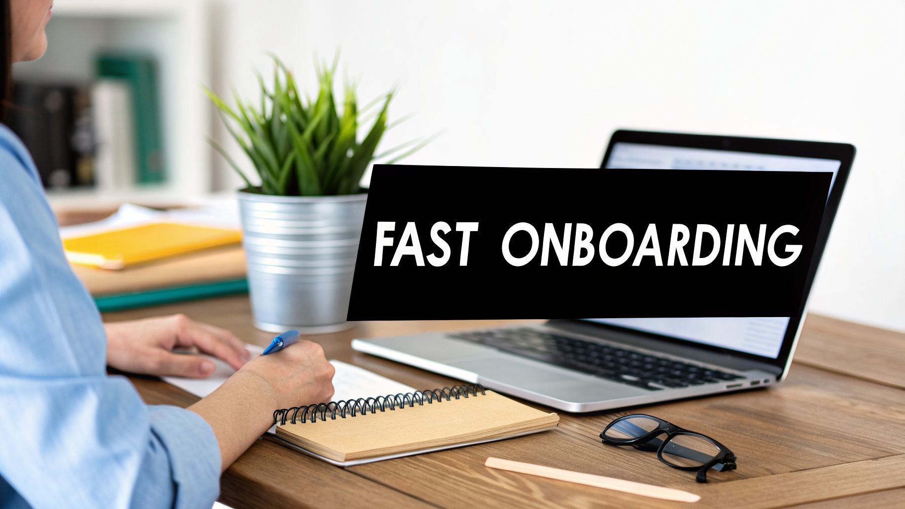 A person writing in a notebook at a desk with a laptop and 'FAST ONBOARDING' text.