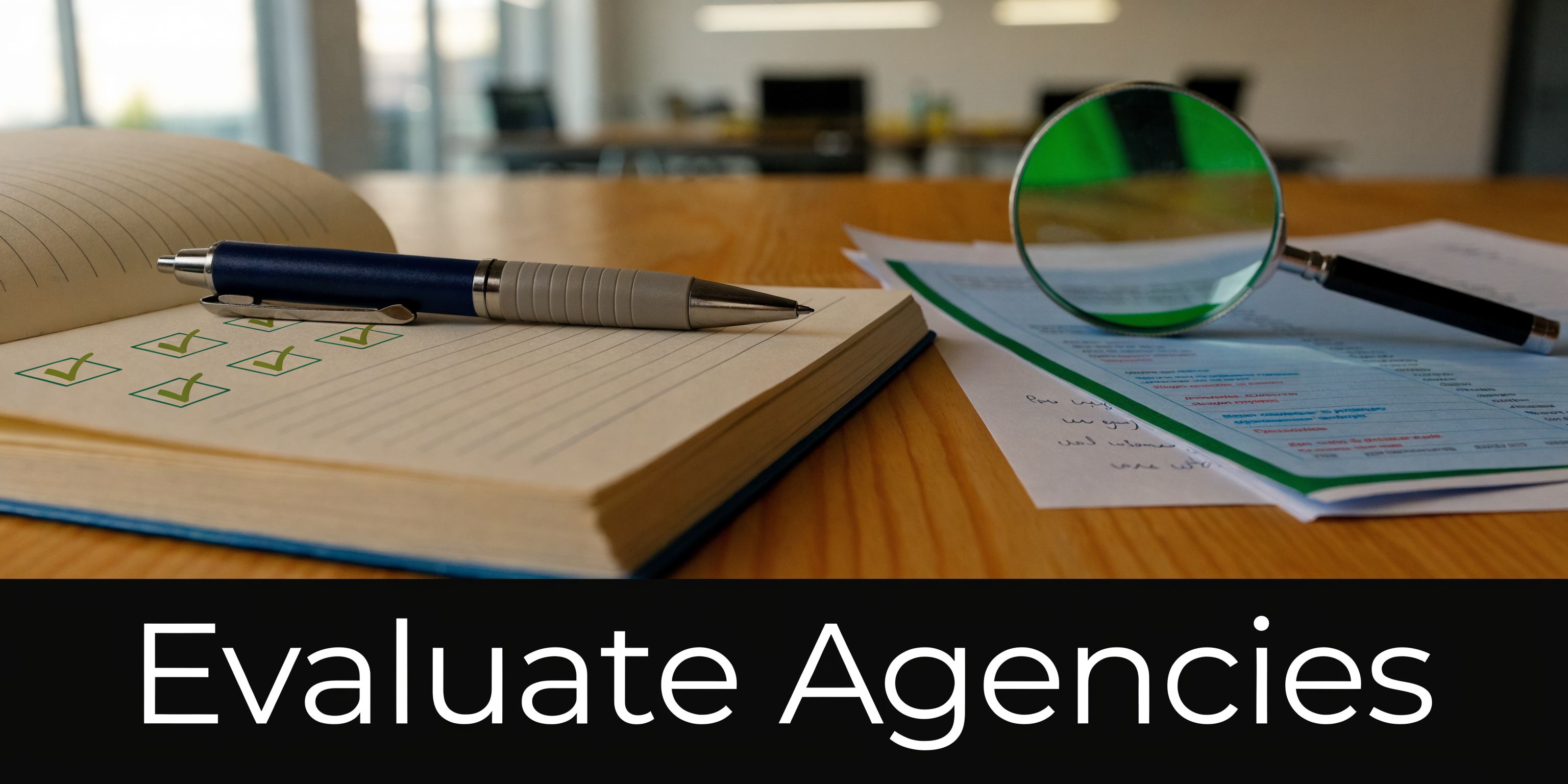 A notepad with checkmarks, a blue pen, and a magnifying glass on an office table for evaluation.