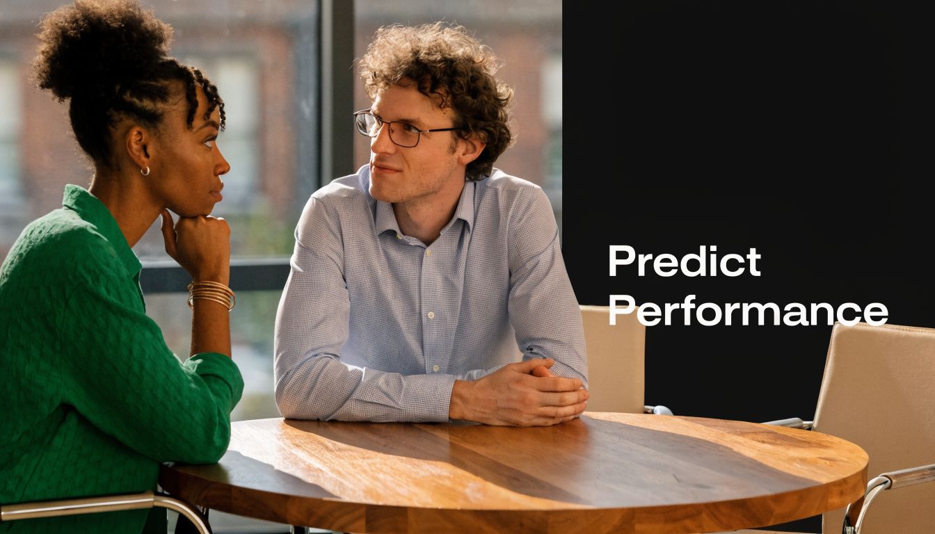A professional man and woman having a serious discussion at a wooden table in an office setting.