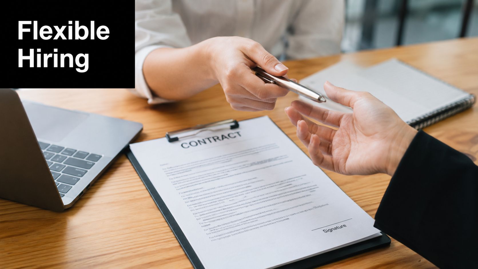A professional handing a pen to a candidate to sign a formal employment contract at a desk.