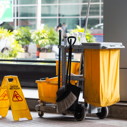 Yeshua Cleaning employee wearing a uniform, meticulously deep cleaning the interior of a bright and airy Miami Airbnb. The room features modern decor with large windows that let in plenty of natural light. The employee is focused on scrubbing the kitchen counter, with various cleaning supplies and equipment neatly arranged around them. The scene emphasizes a professional and thorough cleaning service.