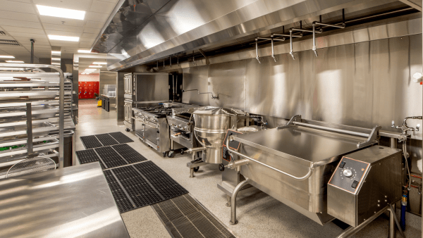 A sparkling clean kitchen in a Miami restaurant, with sanitized countertops, gleaming kitchen equipment, and spotless floors, meticulously cleaned by Yeshua Cleaning professionals.