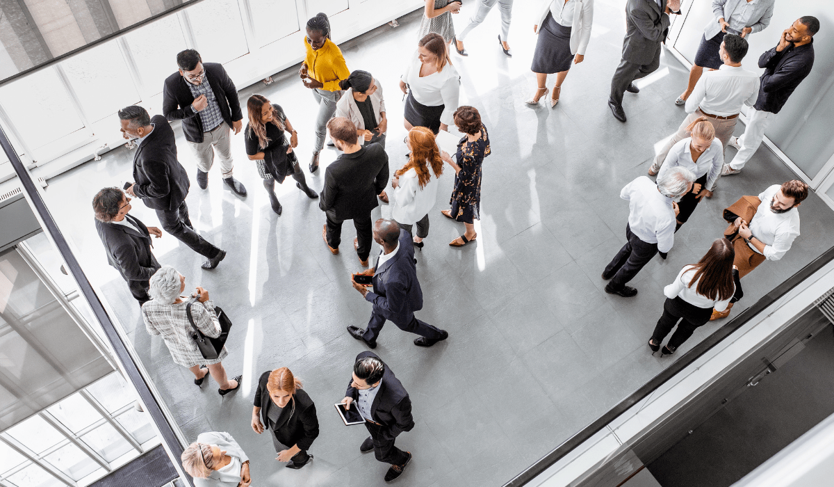 A bustling corporate event with attendees networking in a pristine, well-maintained environment, highlighting the thorough cleaning by Yeshua Cleaning.