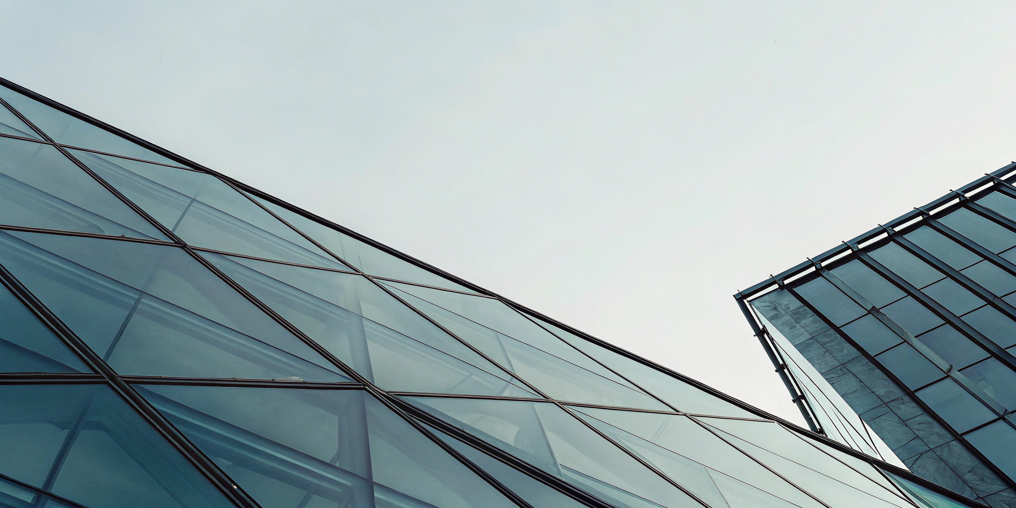 Low-angle view of modern glass office buildings against a clear sky.