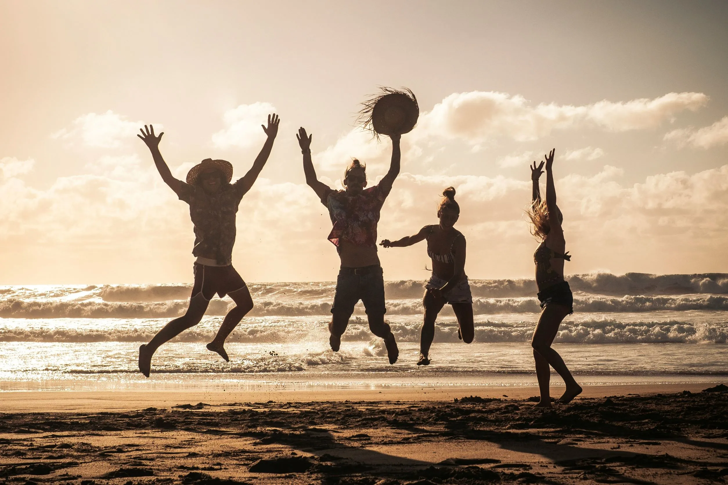 group of people jumping in the air at the beach