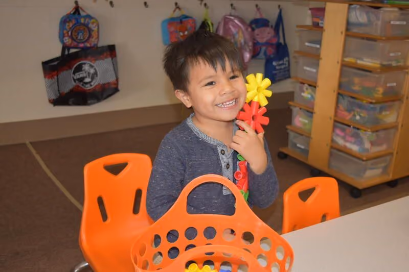 a child playing with a toy smiling
