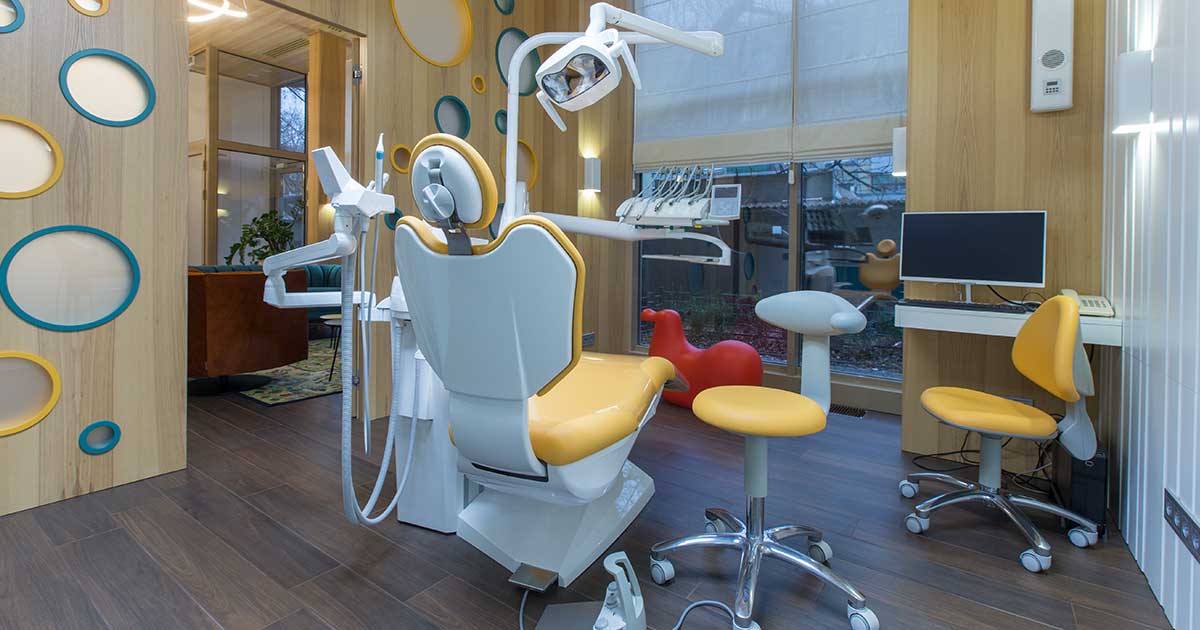 Modern orthodontic treatment room with dental chair, chairside monitor, and wood-accented design in Minnesota
