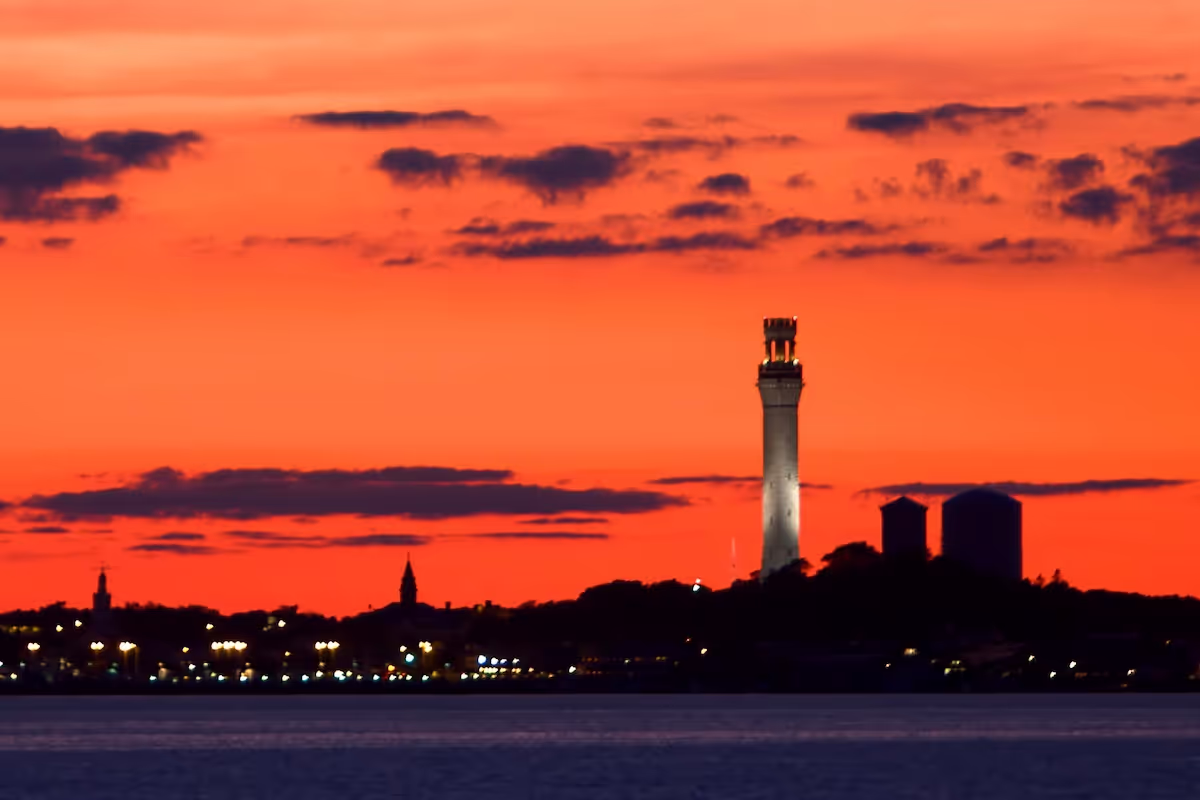 Provincetown, MA skyline including the Pilgrim Monument at sunset.