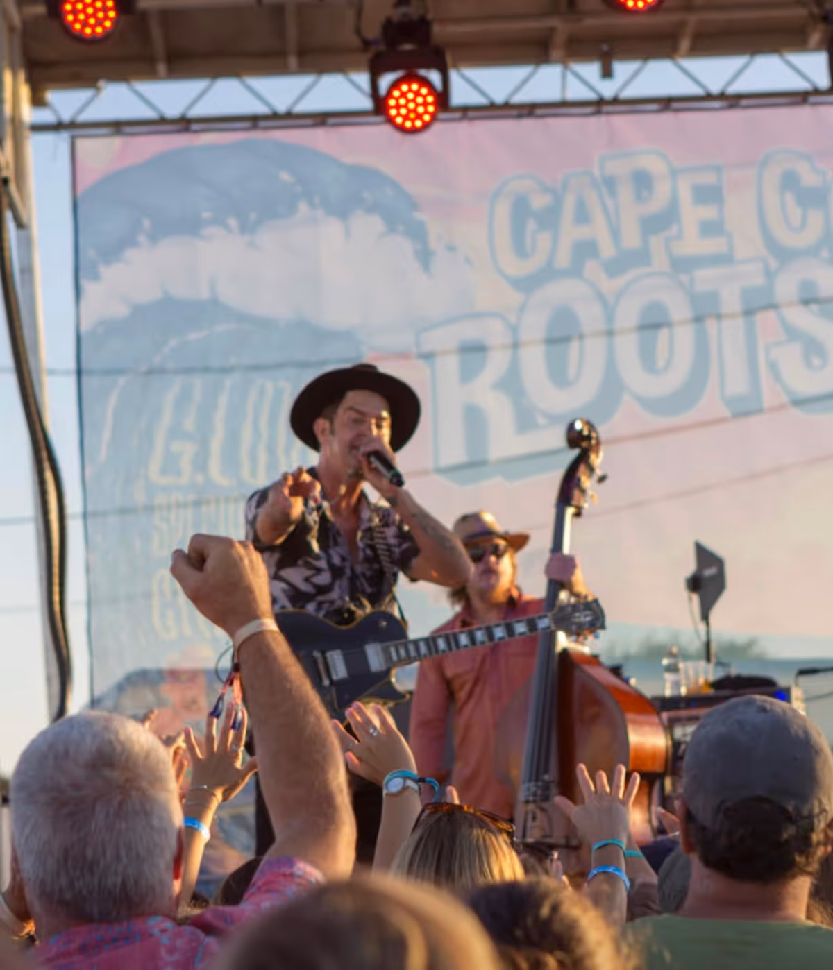 Man singing on stage to a crowd of cheering people