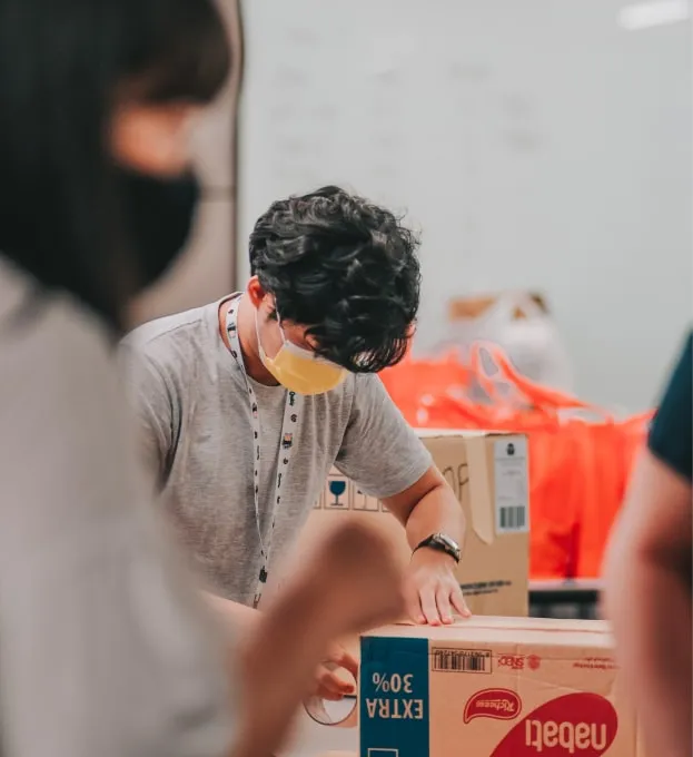 a man wearing a face mask while standing next to a cardboard box