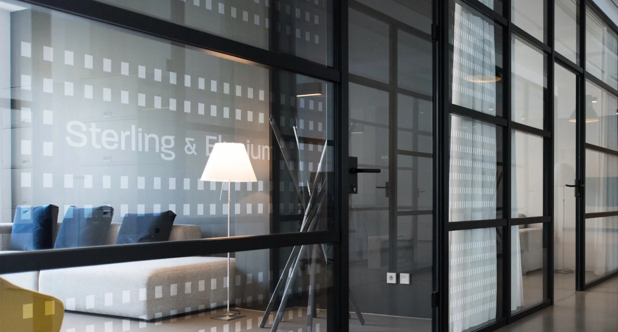 a office room filled with furniture and a large window
