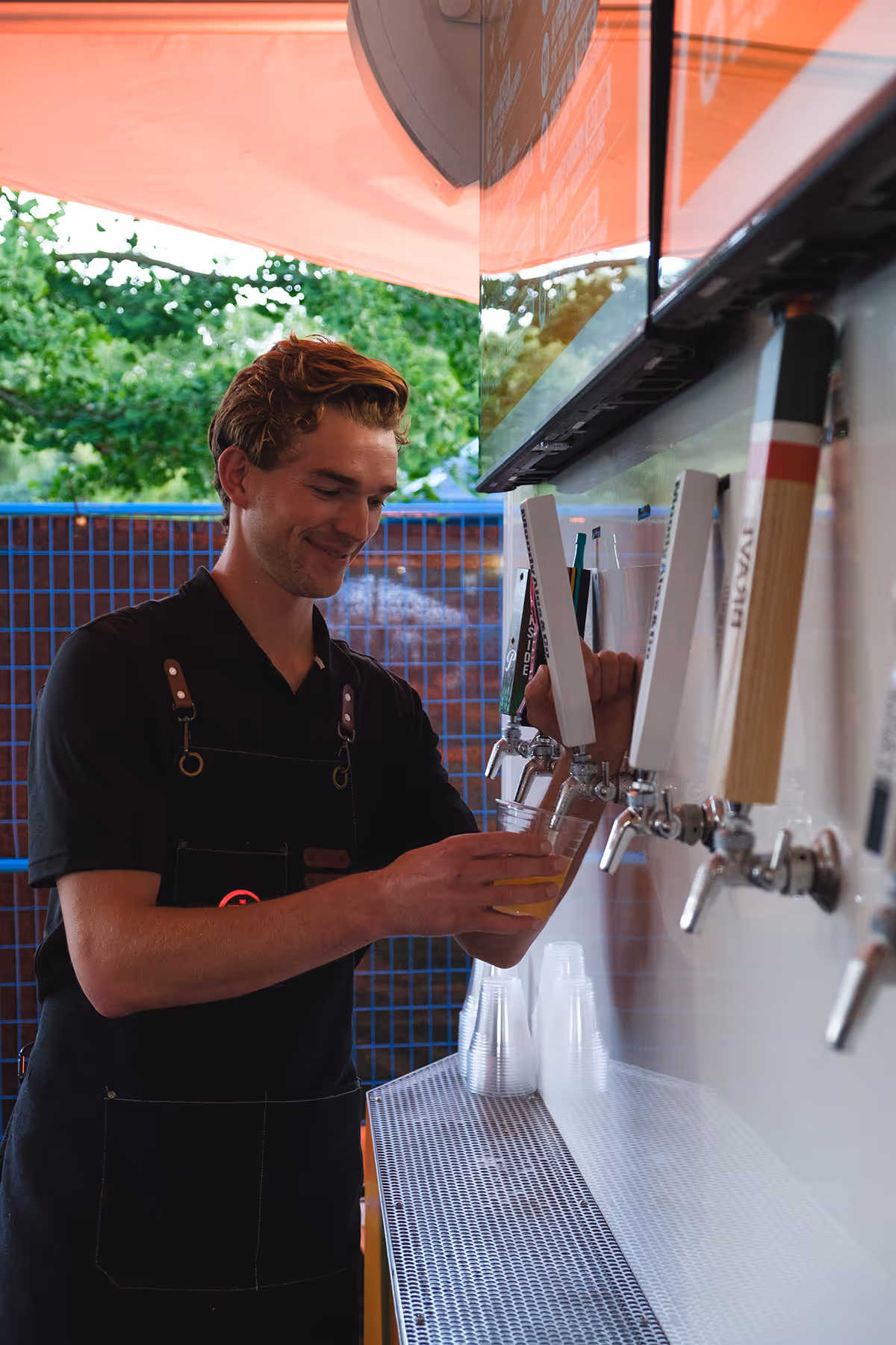 A Perfect Pour Tapster pouring a beer from a tapped trailer.