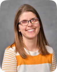Talea is a white woman with glasses and shoulder-length brown hair