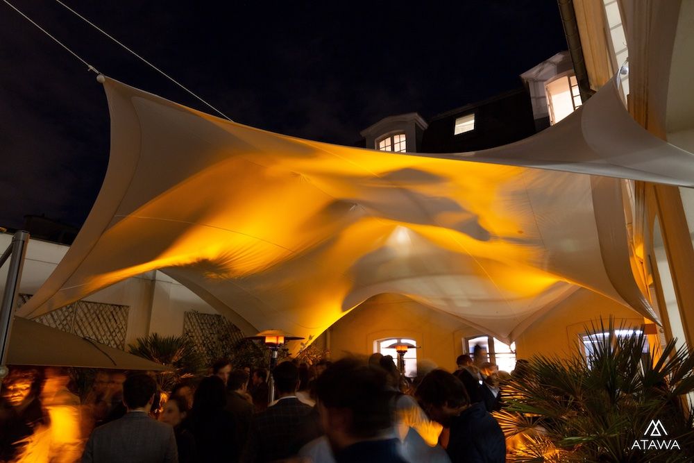 Soirée d'entreprise dans une cour sous une toile lycra à Paris