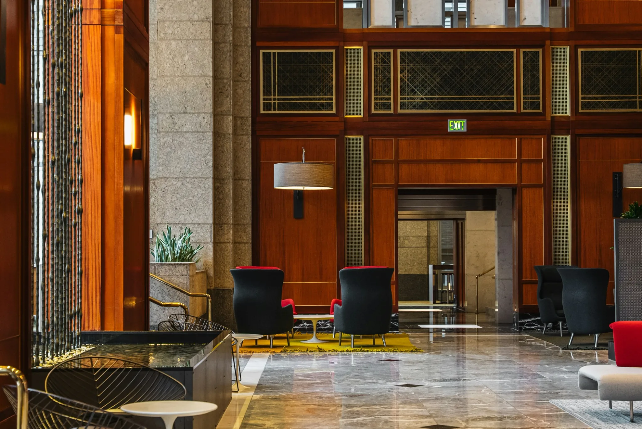 Lobby modern cu finisaje din lemn, fotolii si podea din marmura. Foto: Josh Hild / Unsplash