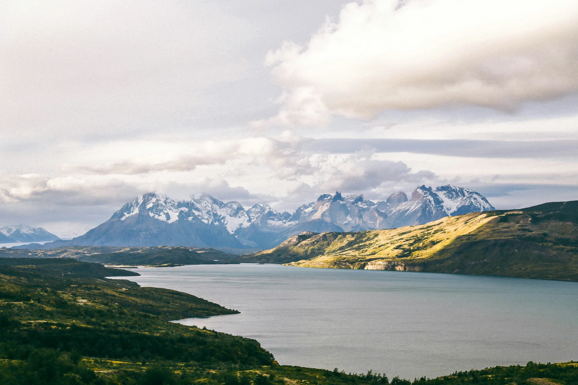 Parcul Torres del Paine din Patagonia, Chile, cu lac si varfuri stancoase acoperite de zapada sub nori. Foto: Peter Winckler / Unsplash