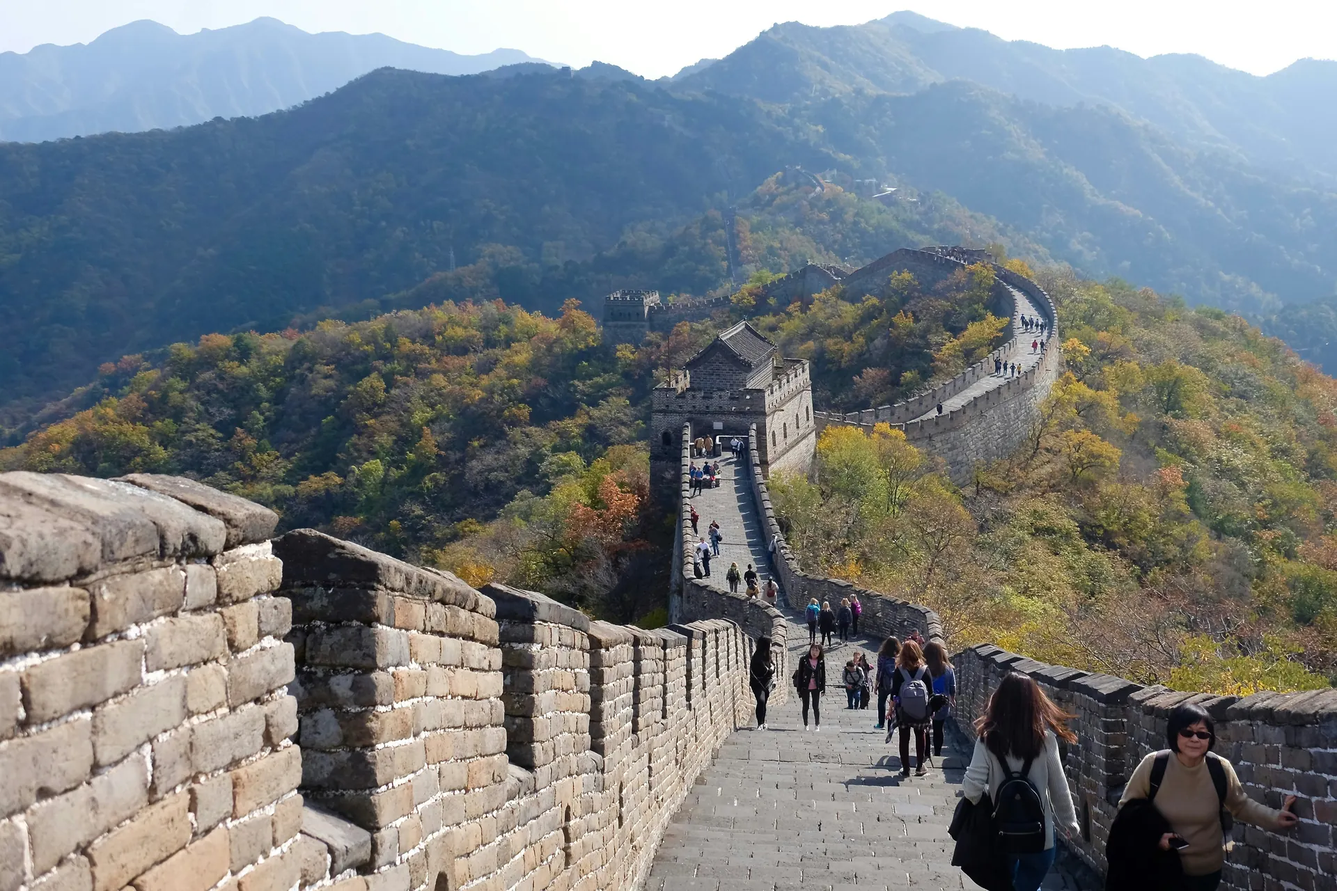 Turisti pe sectiunea Mutianyu a Marelui Zid Chinezesc, printre paduri de toamna. Foto: Bruce Rottgers / Unsplash