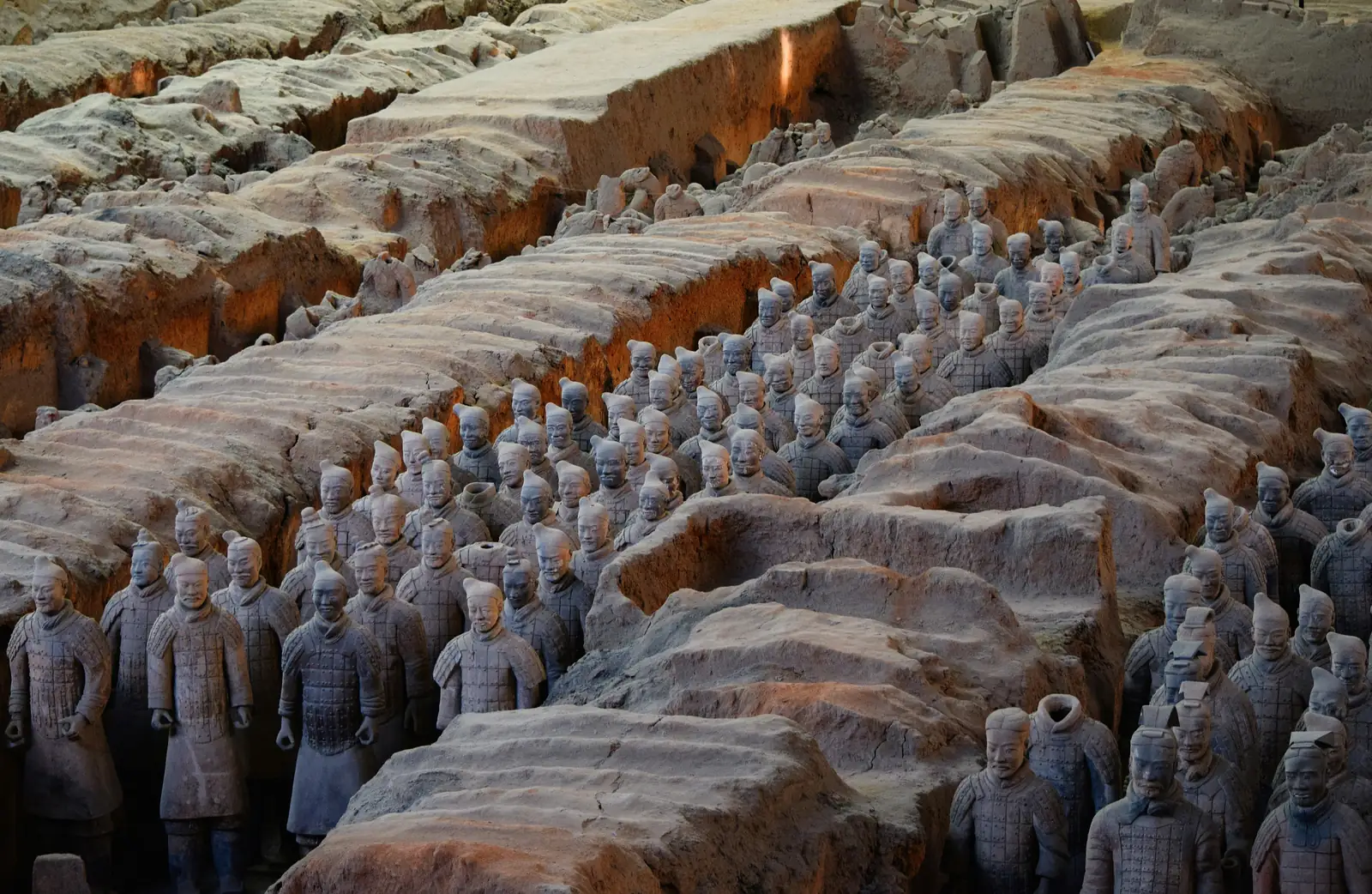 Statui ale Armatei de Teracota aliniate intre zidurile de pamant ale gropii excavate, langa Xi'an, China. Foto: Aaron Greenwood / Unsplash
