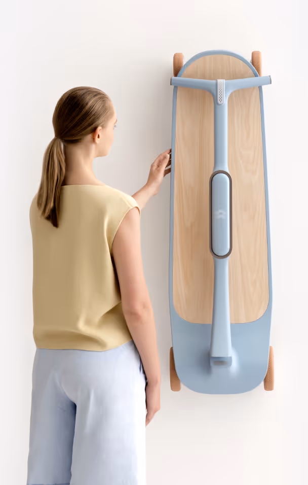 Woman with a ponytail standing next to a modern electric scooter mounted vertically on a wall.