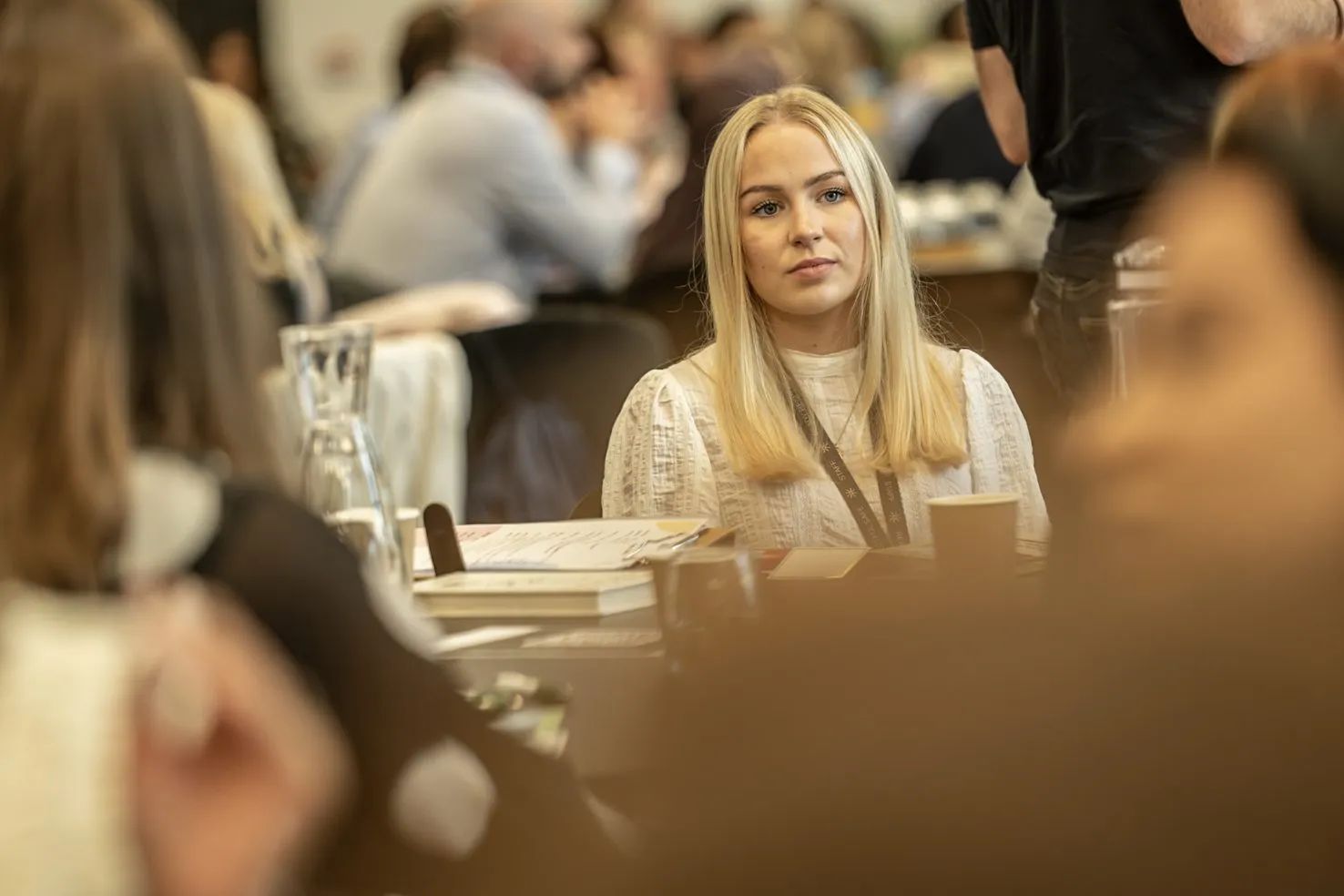 A delegate mid-conversation at a Leeds business conference, photographed from a distance with a longer lens by Dock Street Studio